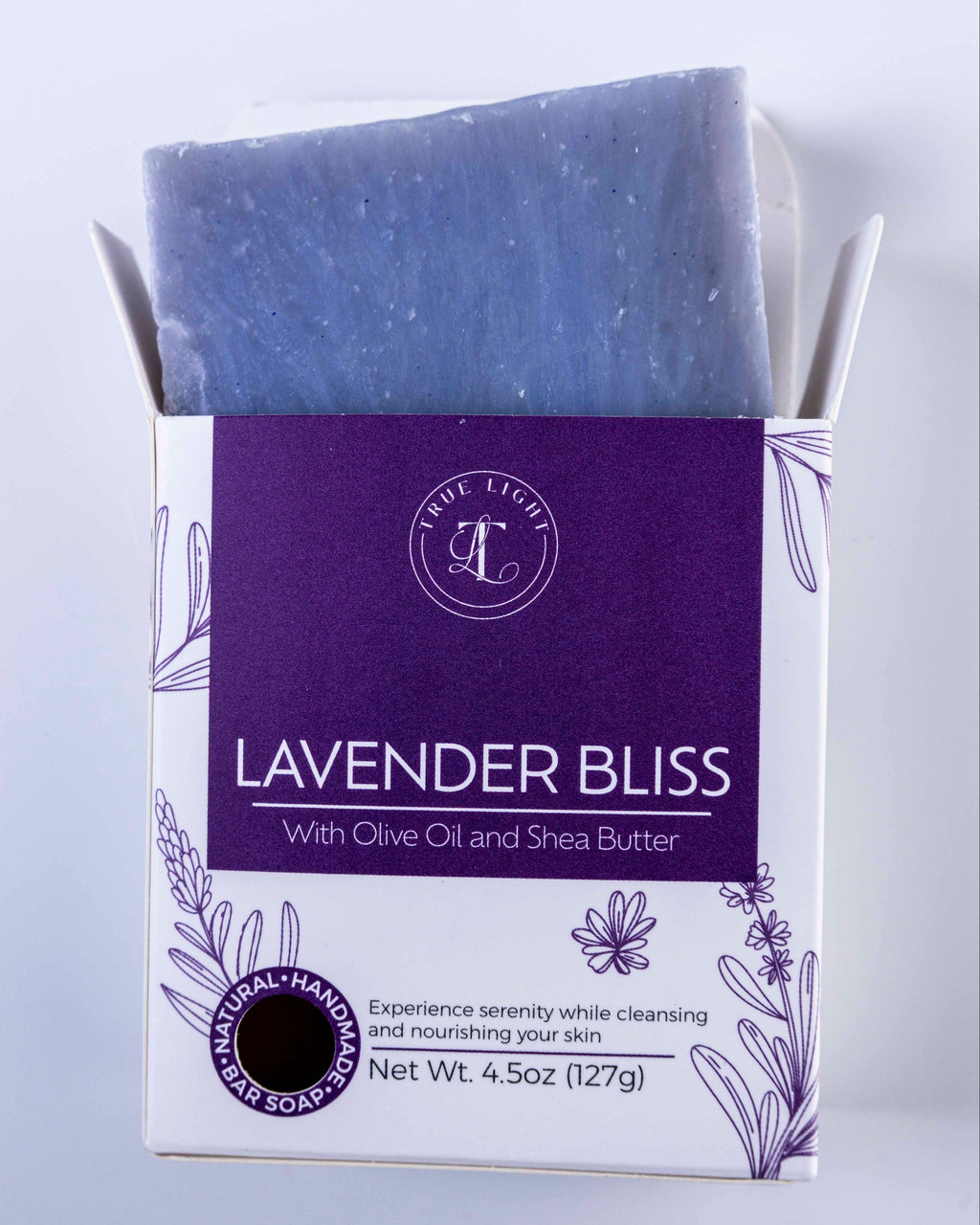 Lavender Bliss soap bar with packaging on a light gray background